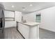 Bright kitchen with a center island, stainless steel appliances, and ample cabinet space at 3736 Bergamot St, Lake Alfred, FL 33850