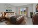 Staged bedroom with a view to the outside, a wooden bed, and an area rug over laminate flooring at 12921 Sw 64Th Terr Rd, Ocala, FL 34473