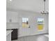 Kitchen eating area features a modern light fixture, a door to the outside, and a window overlooking the yard at 12921 Sw 64Th Terr Rd, Ocala, FL 34473