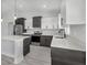 Modern kitchen features two-tone cabinetry, stainless steel appliances, and a center island with a white countertop at 12921 Sw 64Th Terr Rd, Ocala, FL 34473