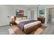 Staged main bedroom features a wood bed frame, nightstands, and a view to the ensuite bathroom at 12921 Sw 64Th Terr Rd, Ocala, FL 34473