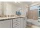 Bathroom with white cabinetry, granite countertops, bathtub and a shower with tile at 321 Auburn Ave, Kissimmee, FL 34747