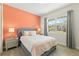 Bedroom featuring a large window, cozy bed with plush pillows, and soft gray carpet, offering comfort and style at 321 Auburn Ave, Kissimmee, FL 34747