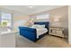 Cozy bedroom featuring a tufted navy bed frame, carpet, and lots of natural light at 321 Auburn Ave, Kissimmee, FL 34747