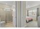 Bedroom and bathroom area with a large window view and glass enclosed shower, showcasing bright natural light at 321 Auburn Ave, Kissimmee, FL 34747