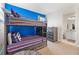 Stylish bunk beds with colorful bedding and a blue accent wall, next to a modern dresser at 321 Auburn Ave, Kissimmee, FL 34747