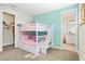 Well-lit bedroom with bunk beds, light gray carpet, and access to a bathroom and walk-in closet at 321 Auburn Ave, Kissimmee, FL 34747