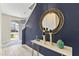 Entryway featuring a round mirror on a blue accent wall and decorative table with tiled floor, creating an elegant foyer at 321 Auburn Ave, Kissimmee, FL 34747