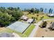 Expansive lakefront property with tennis courts, manicured grounds, palm trees, and a charming house with ample parking at 5144 Riverlake Dr, Bartow, FL 33830