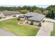 Charming home with stone accents, a well-manicured lawn, fountain, and long driveway leading to the attached garage at 5144 Riverlake Dr, Bartow, FL 33830