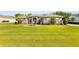 Inviting single-story home with a manicured lawn, stone accents, and a charming circular driveway featuring a central fountain at 5144 Riverlake Dr, Bartow, FL 33830