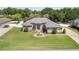 Charming single-story home featuring stone accents, a well-manicured lawn, and a circular driveway with a central fountain at 5144 Riverlake Dr, Bartow, FL 33830