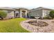 Up close shot of a home's circular paver driveway and fountain feature, surrounded by vibrant flowerbeds and lush greenery at 5144 Riverlake Dr, Bartow, FL 33830