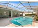 Screened-in pool area with clear blue water, comfortable seating, and lush landscaping, creating a relaxing outdoor oasis at 5144 Riverlake Dr, Bartow, FL 33830