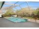 Sparkling in-ground pool with a screen enclosure, surrounded by lush greenery and patio space at 5144 Riverlake Dr, Bartow, FL 33830
