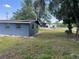 Spacious backyard featuring a detached garage or workspace, surrounded by mature trees at 5580 Hwy 542 W, Winter Haven, FL 33880