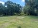 Beautiful tree-lined backyard with lush green grass and open space, perfect for outdoor activities at 5580 Hwy 542 W, Winter Haven, FL 33880