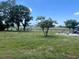 Expansive backyard with mature trees and a partial fence for added privacy at 5580 Hwy 542 W, Winter Haven, FL 33880