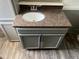Close up of a grey vanity with dark hardware, granite countertops and wood flooring in the bathroom at 5580 Hwy 542 W, Winter Haven, FL 33880