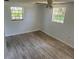 Clean bedroom featuring wood-look tile flooring, complemented by natural light from the windows at 5580 Hwy 542 W, Winter Haven, FL 33880