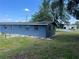 Exterior side view of the home surrounded by green grass and scattered trees at 5580 Hwy 542 W, Winter Haven, FL 33880