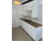 An efficiently designed kitchen with granite countertops, a stainless steel faucet, and white cabinetry at 5580 Hwy 542 W, Winter Haven, FL 33880