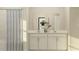 Bright bathroom featuring a dual sink vanity and shower with a patterned shower curtain at 698 Peroni Ave, Debary, FL 32713