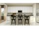 A modern kitchen with white cabinetry and black barstools at the breakfast bar at 698 Peroni Ave, Debary, FL 32713