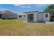 View of the backyard with a well maintained lawn, concrete patio, and white exterior home at 1475 3Rd Ave, Deland, FL 32724