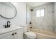 Bathroom featuring a white marble tiled shower and round mirror at 1475 3Rd Ave, Deland, FL 32724