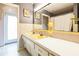 Bathroom featuring a large mirror over double sinks, with grey walls and tiled flooring at 2908 Maplewood Ave, Lakeland, FL 33803