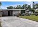 A single-story home with xeriscaping and a covered carport in the front of the home at 2908 Maplewood Ave, Lakeland, FL 33803