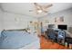 Comfortable bedroom with hardwood floors, bed, ceiling fan, desk, and ample natural light at 3365 Bahama Ct, Lake Wales, FL 33898