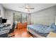 A bedroom with hardwood floors, a ceiling fan, a dresser, a bed, and a desk at 3365 Bahama Ct, Lake Wales, FL 33898