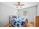 Cozy bedroom features a wooden framed bed with blue patchwork quilt, ceiling fan, and natural light at 3365 Bahama Ct, Lake Wales, FL 33898