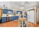 Bright kitchen with blue cabinets, stainless steel appliances, and a wooden island on wood-look flooring at 3365 Bahama Ct, Lake Wales, FL 33898