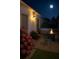 Backyard featuring a hot tub, fire pit, and manicured landscaping illuminated by moonlight at 3533 Roanoke St, The Villages, FL 32162