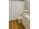 Bathroom featuring light wood floors, a shower with a curtain, and a granite-topped vanity at 3533 Roanoke St, The Villages, FL 32162