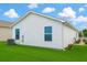 Exterior view of a well maintained yard, showing lawn, potted flowers, and small seating area at 3533 Roanoke St, The Villages, FL 32162