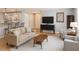 Comfortable living room with wood floors, neutral furniture, and modern decor adjacent to the kitchen at 3533 Roanoke St, The Villages, FL 32162
