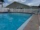 A lovely swimming pool with clear turquoise water, red brick tiles, and a building in the background at 65 Joppa Dr, Winter Haven, FL 33884