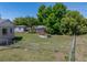 View of the large backyard with green lawn, lush trees, and a chain link fence at 3928 Cherry Way, Lakeland, FL 33805