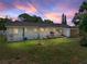 Spacious backyard with lush lawn, small patio, grill and vibrant twilight sky at 3928 Cherry Way, Lakeland, FL 33805