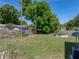 The spacious backyard features lush greenery, mature trees, and a chain link fence at 3928 Cherry Way, Lakeland, FL 33805