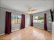 Comfortable bedroom with two windows dressed with maroon curtains, laminate flooring, and a ceiling fan at 3928 Cherry Way, Lakeland, FL 33805