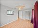 Bright bedroom featuring a ceiling fan, wood floors, and a flat screen TV at 3928 Cherry Way, Lakeland, FL 33805