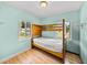 Bedroom featuring bunk beds, wood floors, and a light blue painted wall at 3928 Cherry Way, Lakeland, FL 33805