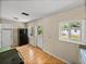 Cozy kitchen with white cabinets, laminate floors, a refrigerator and a calendar with a view to the outside at 3928 Cherry Way, Lakeland, FL 33805