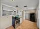 Functional kitchen with an oven, white cabinets, pantry, and refrigerator with a view into the living room at 3928 Cherry Way, Lakeland, FL 33805