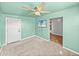 Carpeted room with fresh green walls, a ceiling fan, and a wall-mounted TV at 3928 Cherry Way, Lakeland, FL 33805